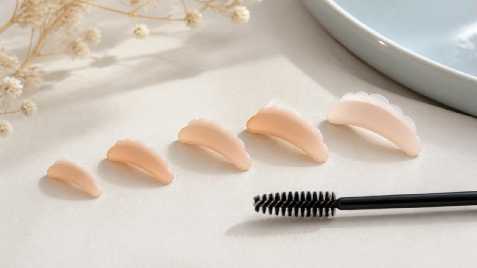 Small to large silicone lash lift shields arranged on a clean beauty surface